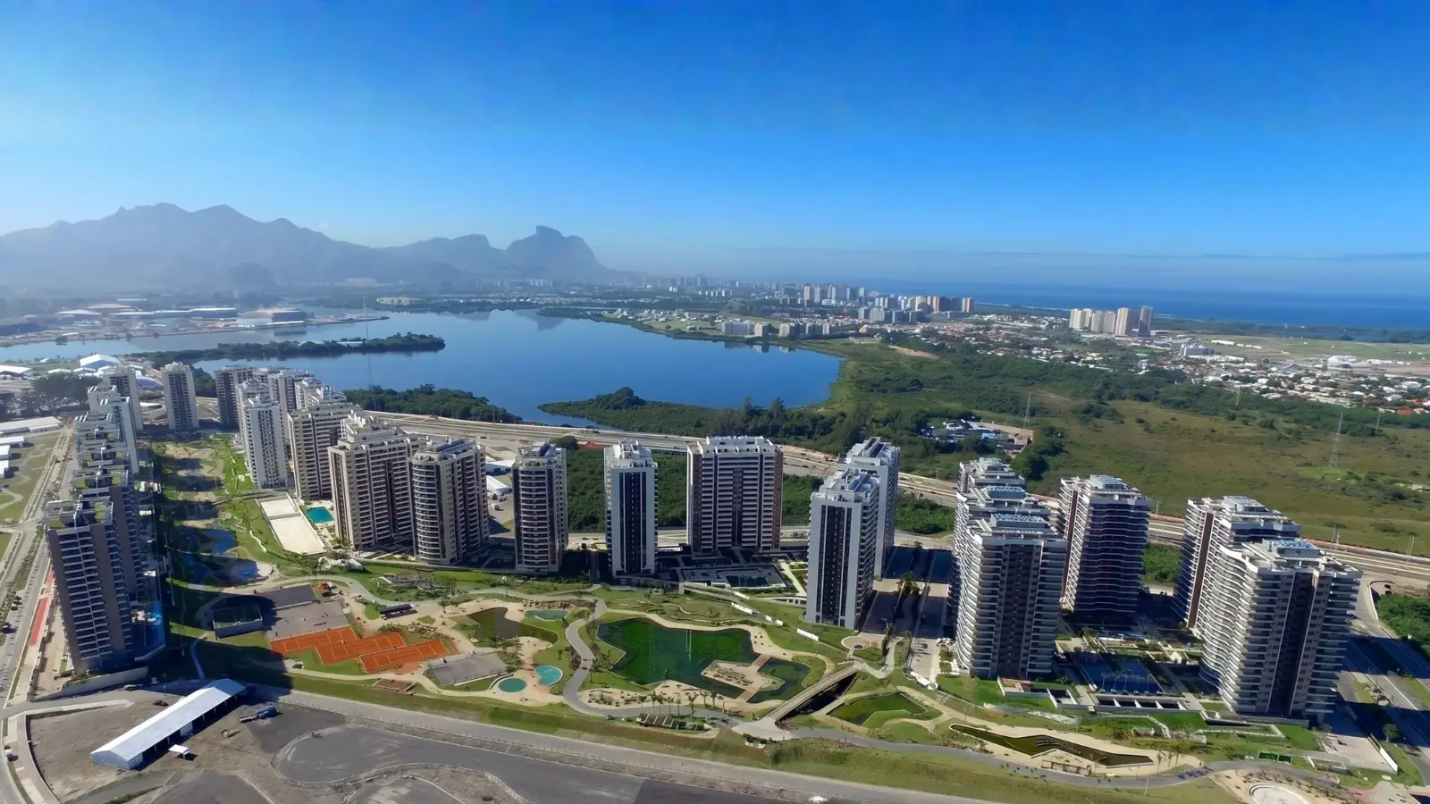 Vista aérea dos empreendimentos do Ilha Pura, com paisagismo e lagoa ao fundo